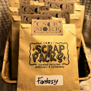 A basket of kraft paper envelopes containing paper craft supplies.